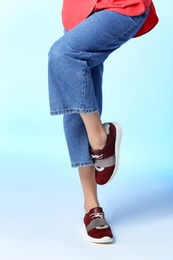 Woman in stylish shoes on color background, closeup