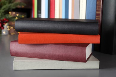 Photo of Stack of hardcover books on grey table indoors, closeup