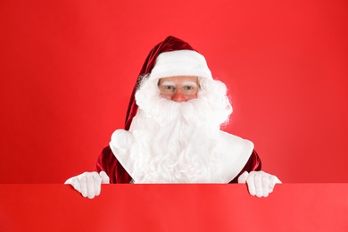 Santa Claus holding empty banner on red background