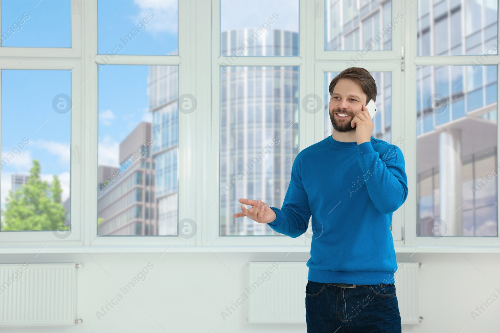 Photo of Man in casual clothes talking on phone indoors, space for text