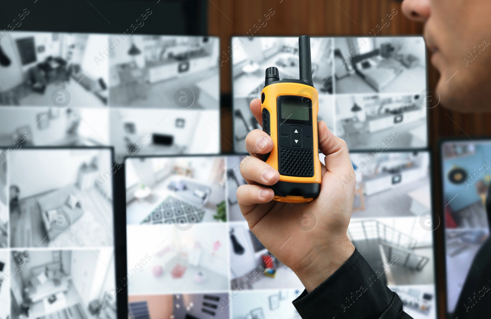 Photo of Security guard using portable transmitter at workplace, closeup