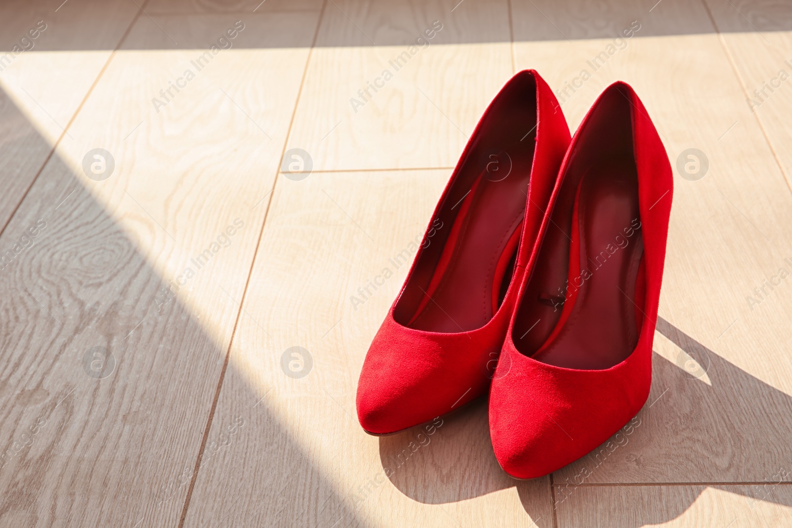 Photo of Pair of red female shoes on floor