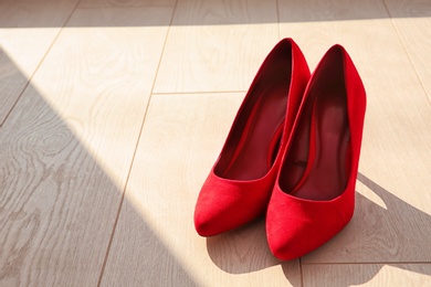 Photo of Pair of red female shoes on floor