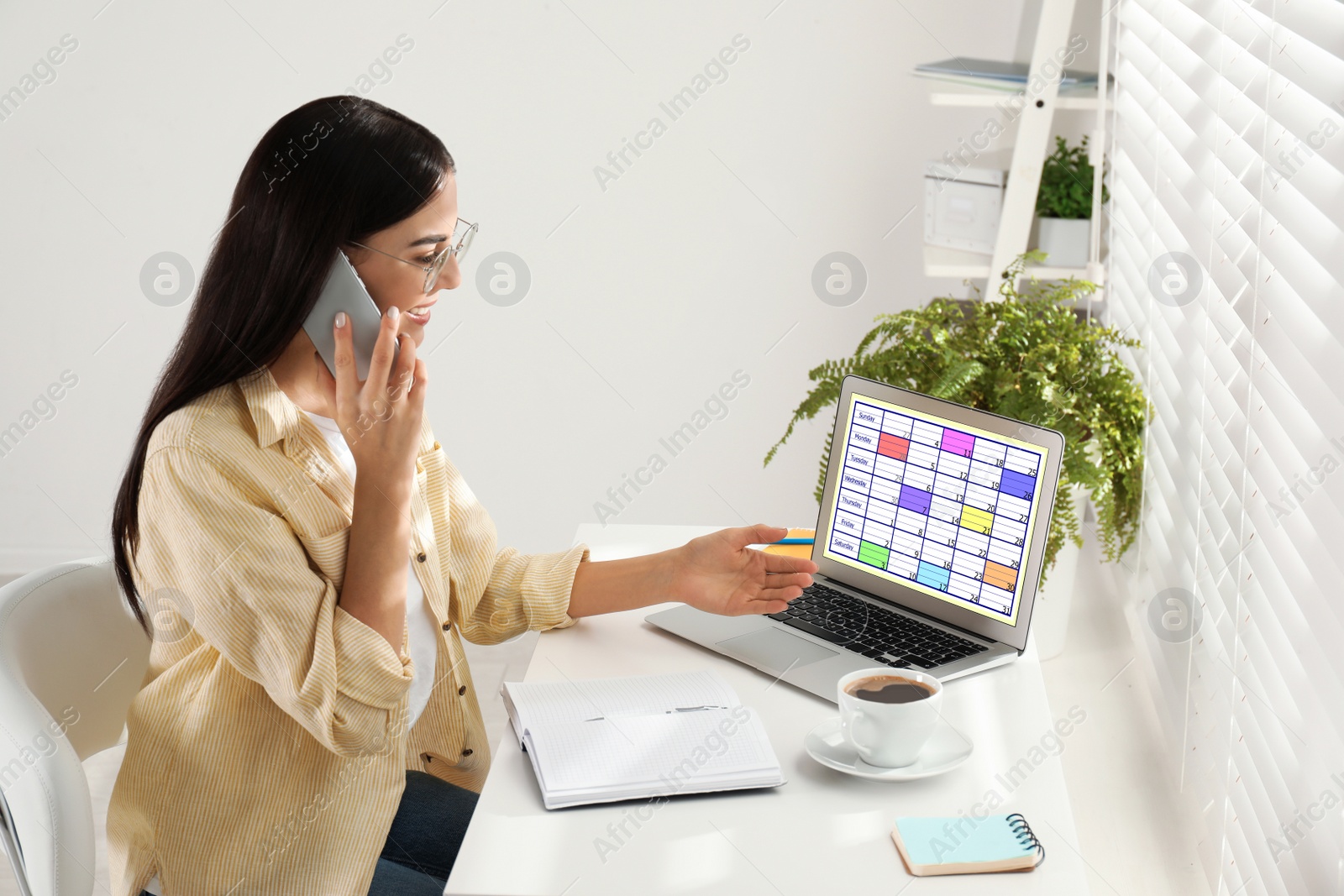 Photo of Young woman planning her schedule with calendar app on laptop in office