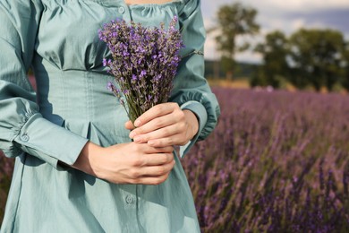 Woman with bouquet of lavender outdoors, closeup. Space for text