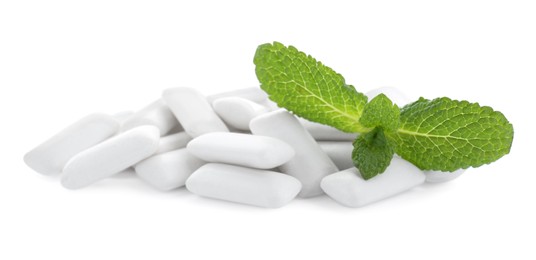 Photo of Heap of chewing gum pieces and mint on white background