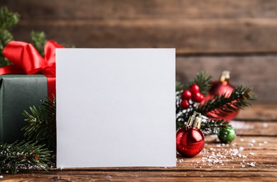 Blank Christmas card and festive decor on wooden table, closeup. Space for text