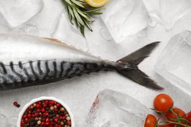 Photo of Raw mackerel, peppercorns and ice on light gray table, flat lay