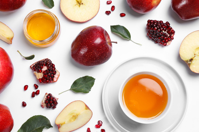 Honey, apples and pomegranates on white background, flat lay. Rosh Hashanah holiday