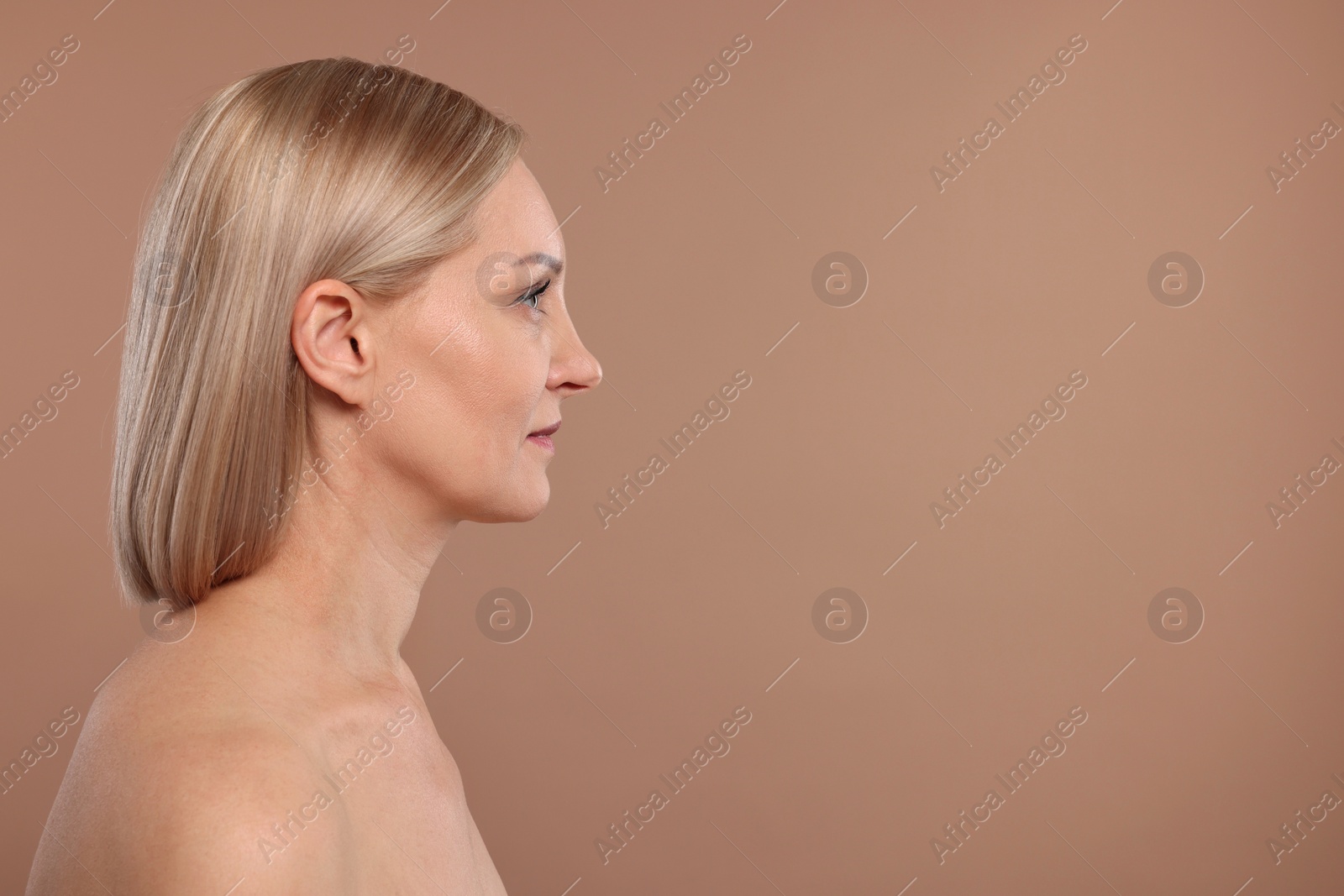 Photo of Beautiful woman touching her neck on beige background, space for text