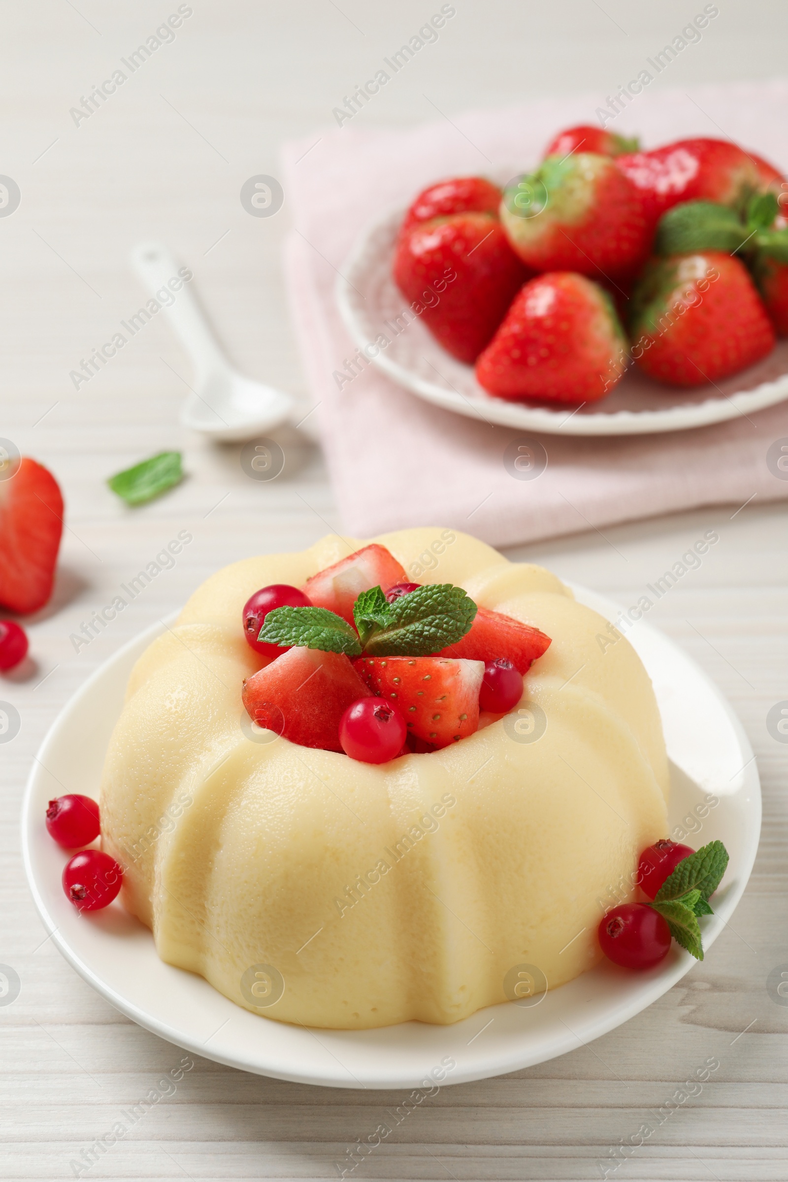 Photo of Delicious semolina pudding with berries on white wooden table