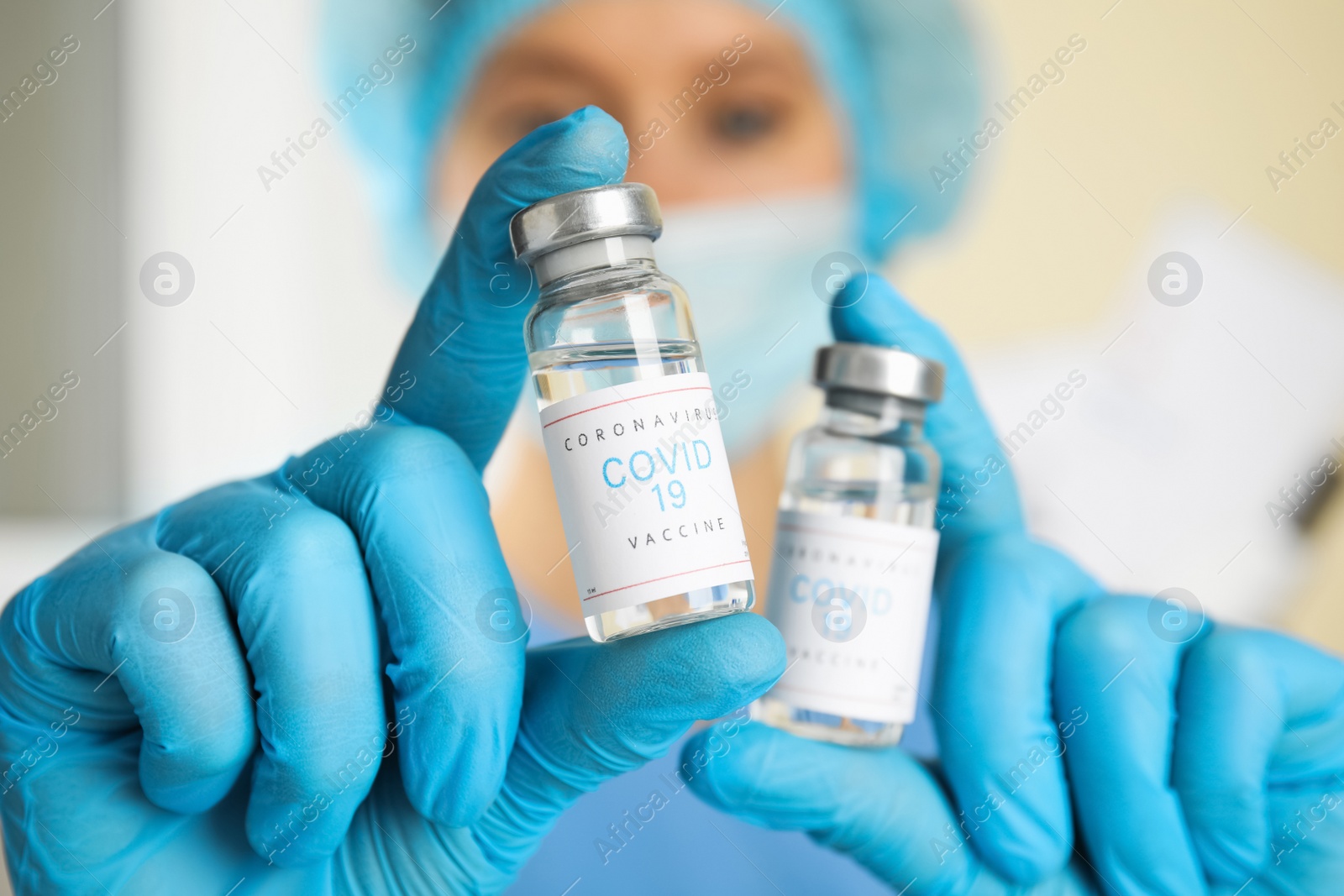 Photo of Doctor holding vials with vaccine against Covid-19 indoors, closeup