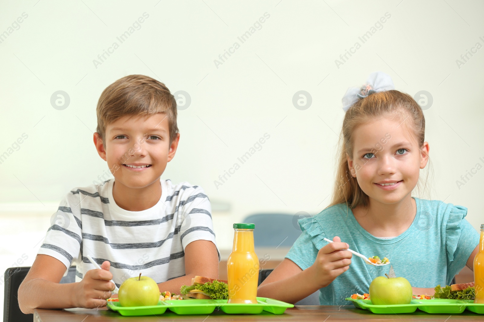 Photo of Happy children eating healthy food for lunch in school canteen