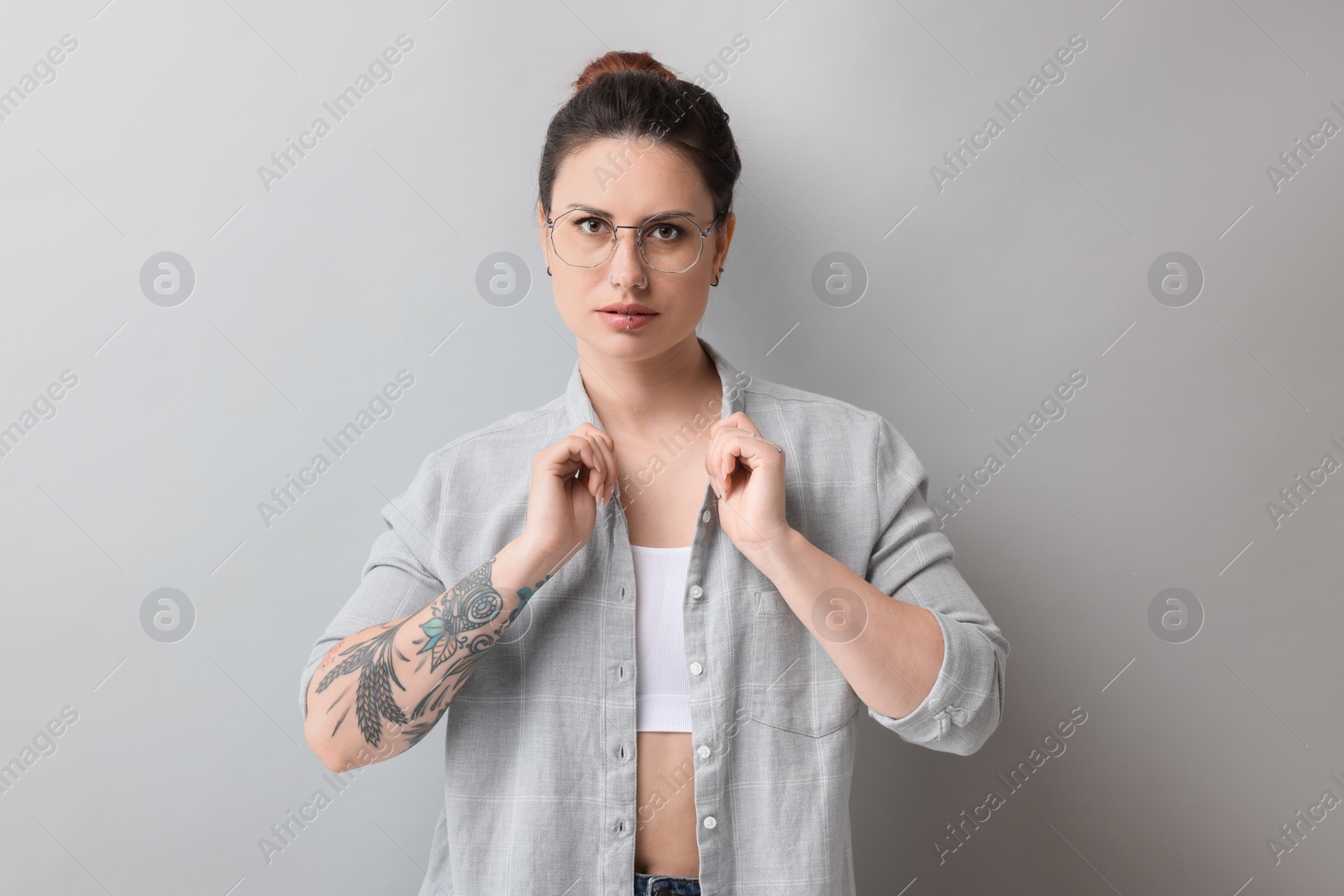 Photo of Portrait of beautiful tattooed woman on gray background