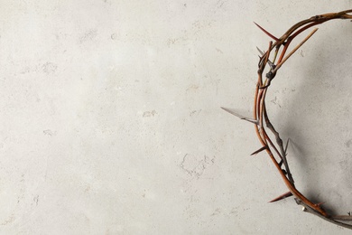 Photo of Crown of thorns on light background, top view with space for text. Easter attribute