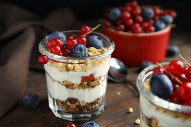 Photo of Delicious yogurt parfait with fresh berries on wooden table, closeup