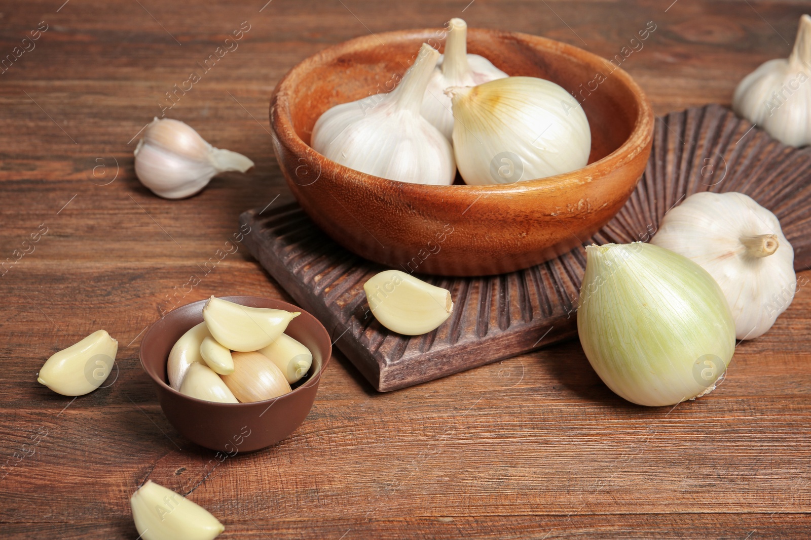 Photo of Composition with onion and garlic on wooden table