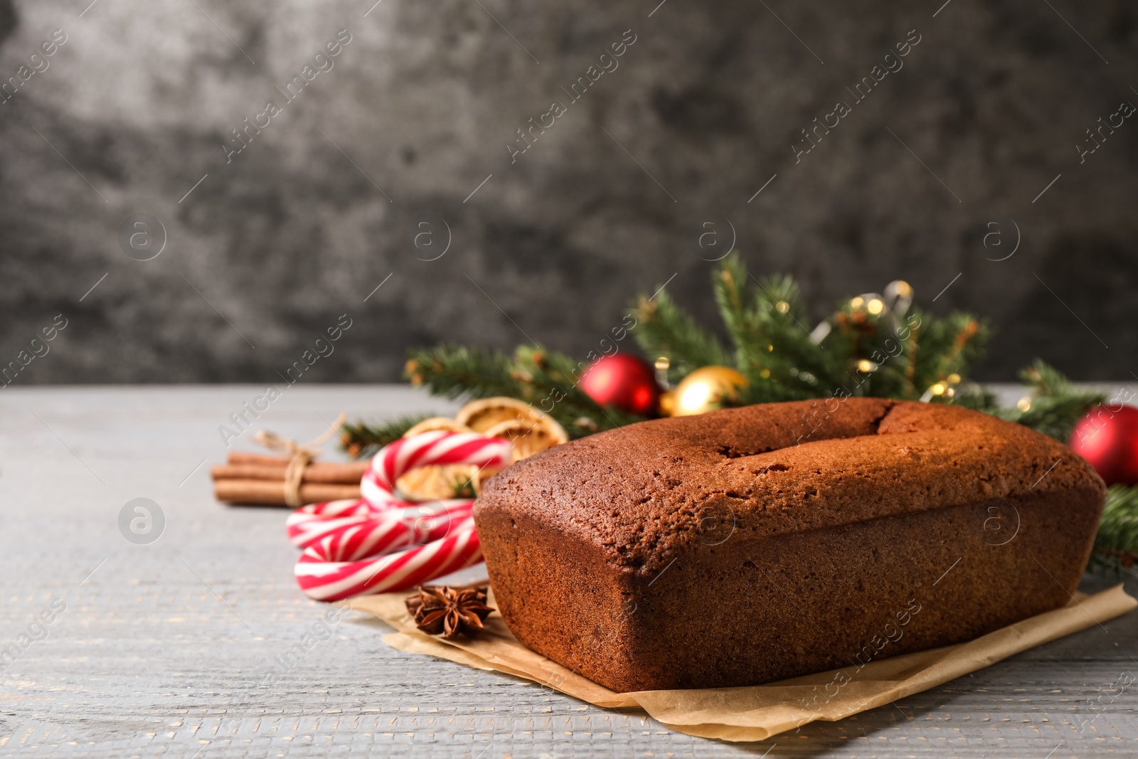 Photo of Delicious gingerbread cake and Christmas items on wooden table, space for text