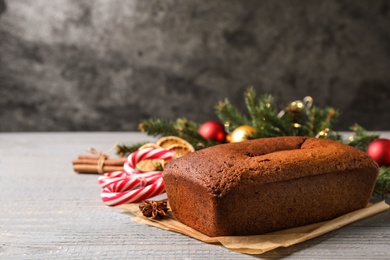 Photo of Delicious gingerbread cake and Christmas items on wooden table, space for text