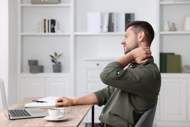 Photo of Man suffering from neck pain in office