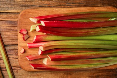 Photo of Many cut rhubarb stalks on wooden table, top view