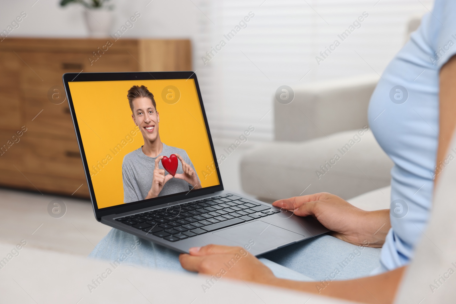 Image of Long distance love. Woman having video chat with her boyfriend via laptop at home, closeup