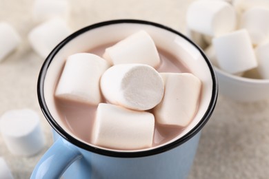 Cup of aromatic hot chocolate with marshmallows on table, closeup