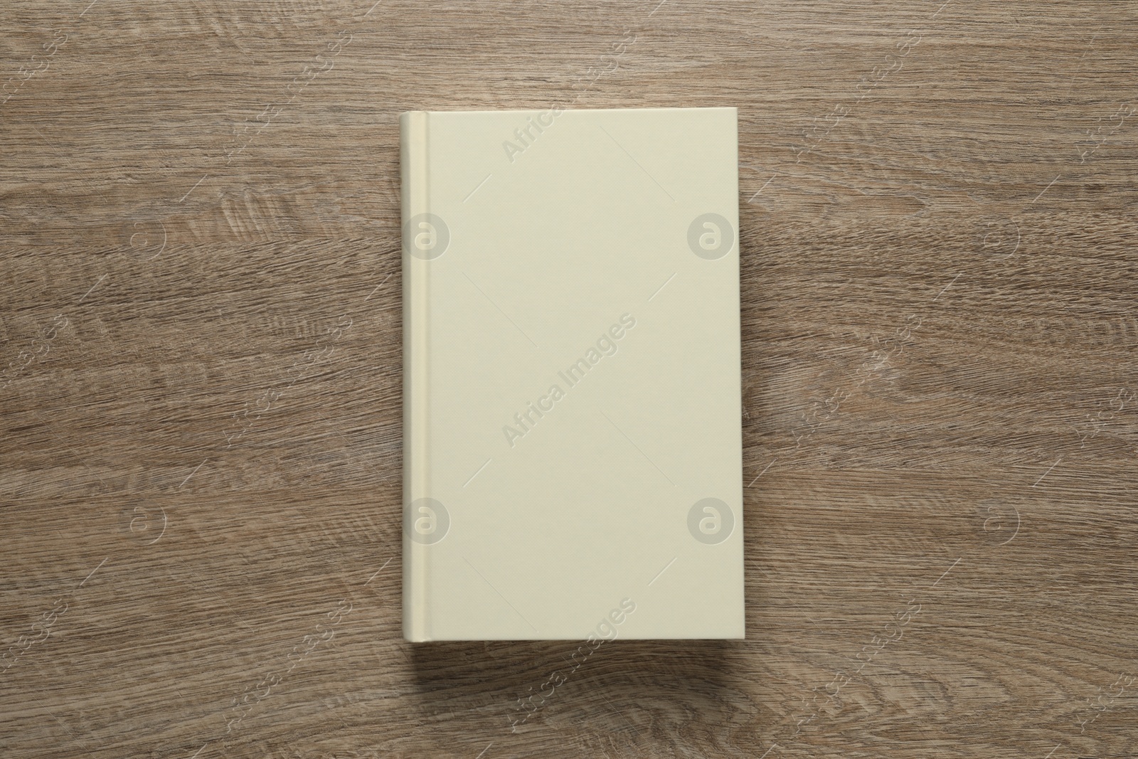 Photo of Closed hardcover book on wooden table, top view