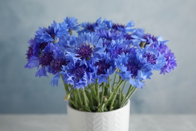 Photo of Bouquet of beautiful blue cornflowers in vase, closeup
