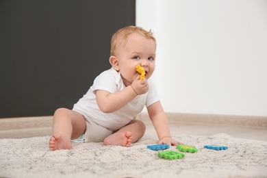 Photo of Cute little baby on rug indoors. Crawling time
