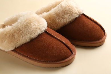 Photo of Pair of stylish soft slippers on beige background, closeup