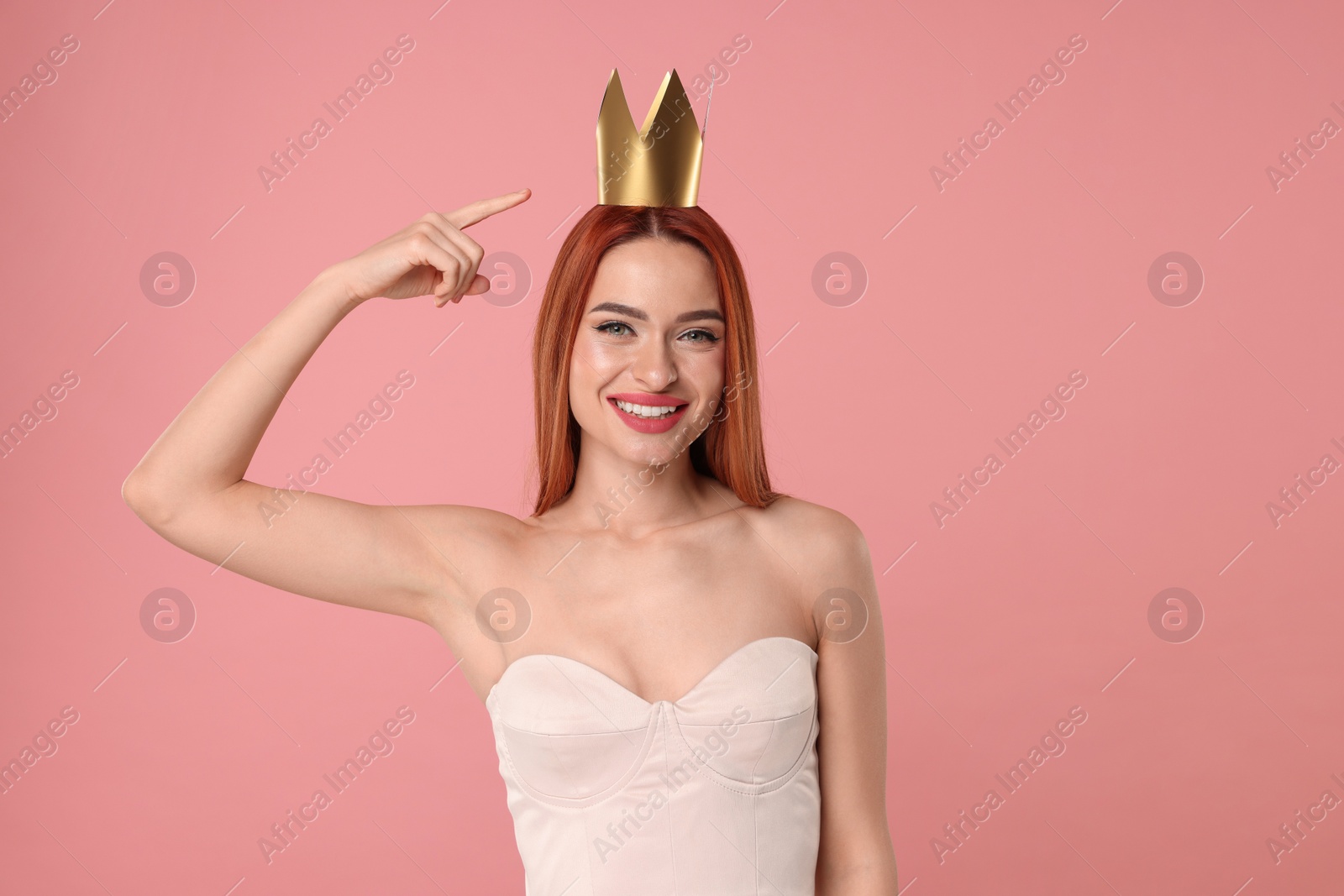 Photo of Beautiful young woman with princess crown on pink background