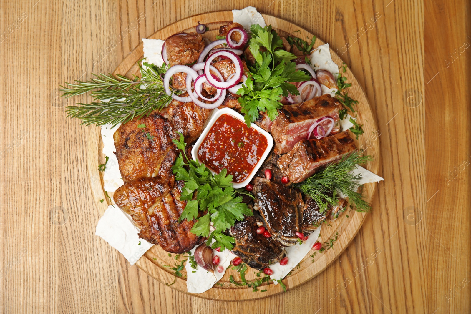 Photo of Delicious roasted meat served on wooden table, top view