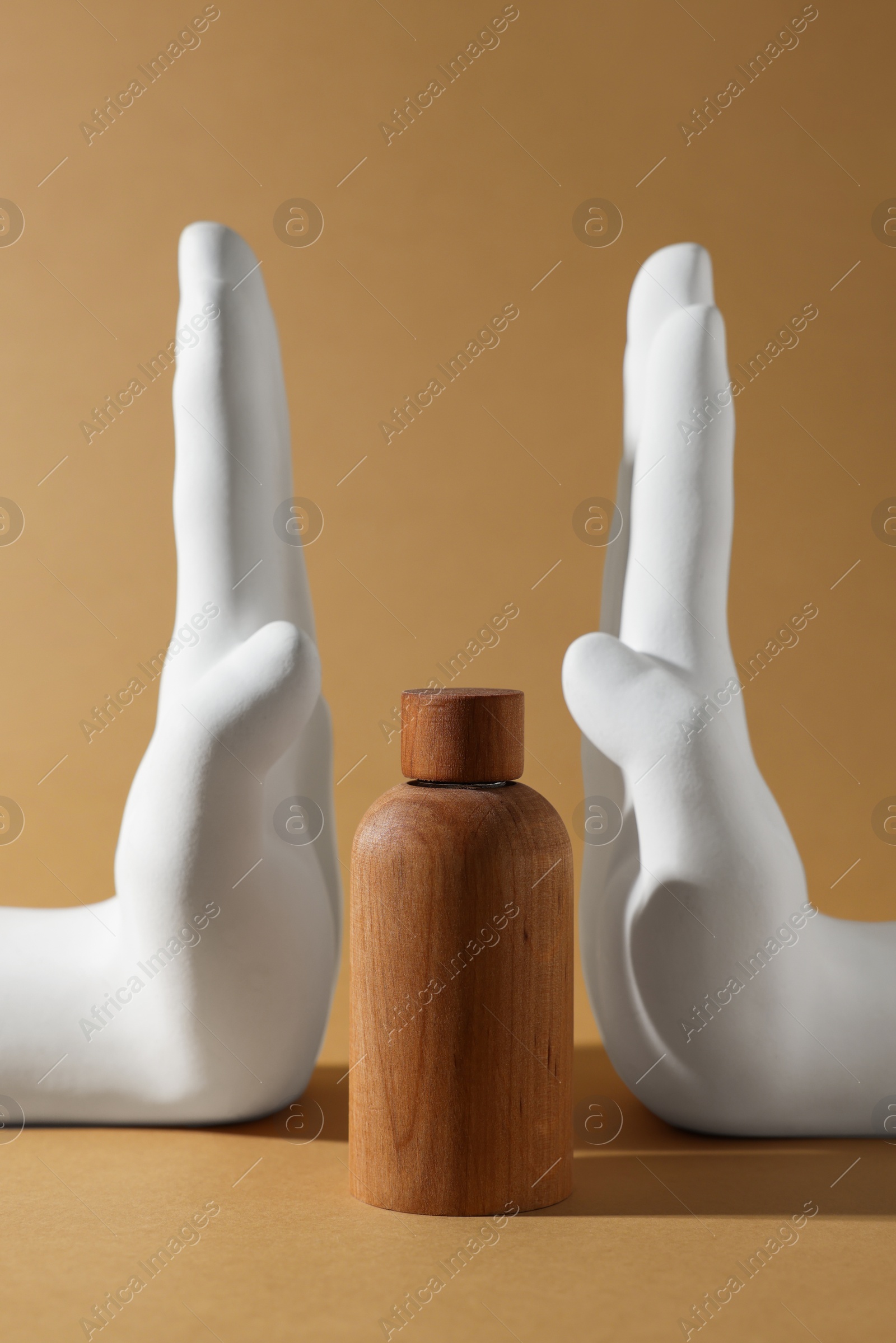 Photo of Composition with wooden bottle of cosmetic product on dark beige background