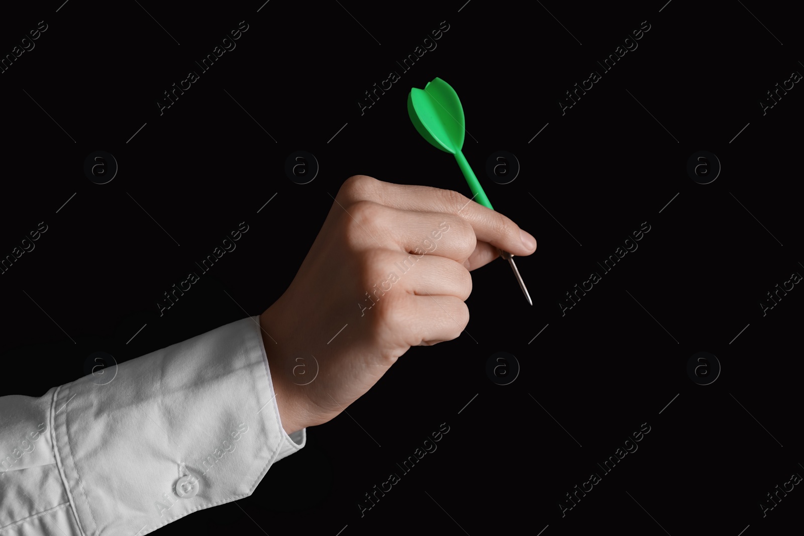 Photo of Businesswoman holding green dart on black background, closeup