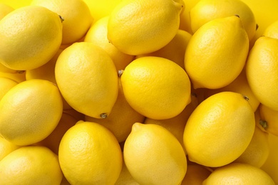 Photo of Ripe lemon fruits as background, top view