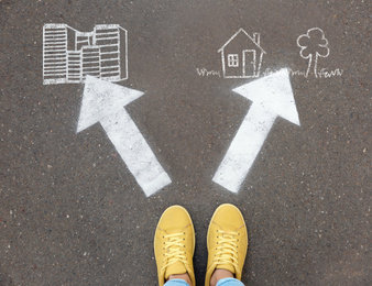 Top view of woman standing near arrows on asphalt, closeup. Concept of balance between life and work 