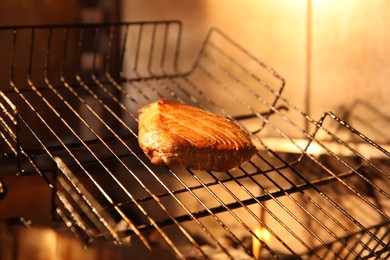 Photo of Grilling basket with tuna in oven, closeup