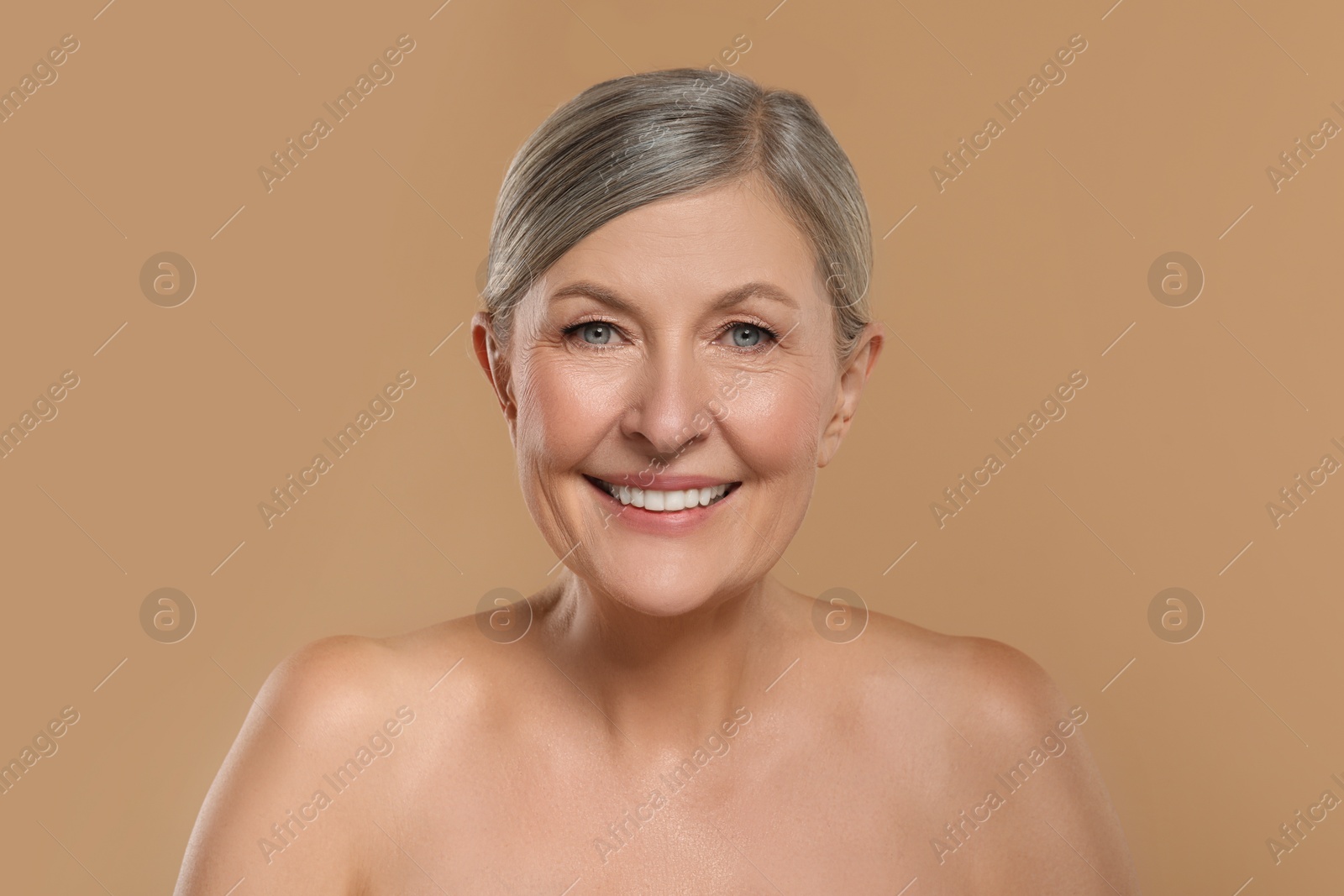 Photo of Beautiful mature woman with healthy skin on beige background