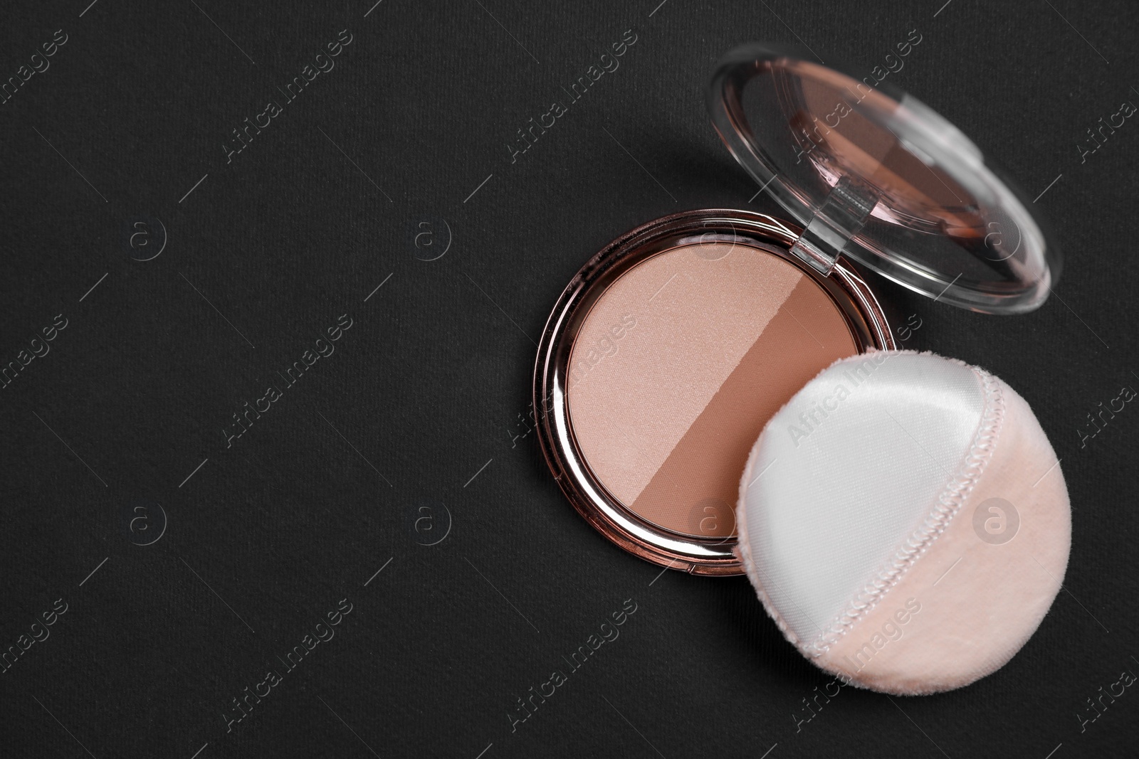 Photo of One open face powder and puff applicator on black background, top view. Space for text