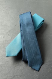 Photo of Two neckties on grey textured background, above view