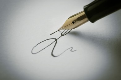 Signing on sheet of paper with fountain pen, closeup