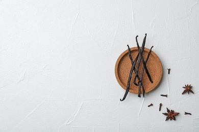 Photo of Plate with aromatic vanilla sticks on white background