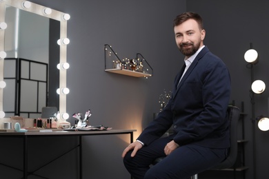 Young handsome bearded man in makeup room