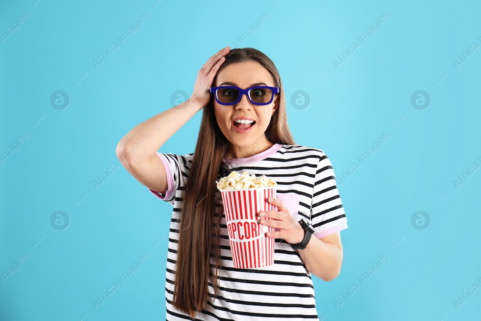 Photo of Emotional woman with 3D glasses and tasty popcorn on color background