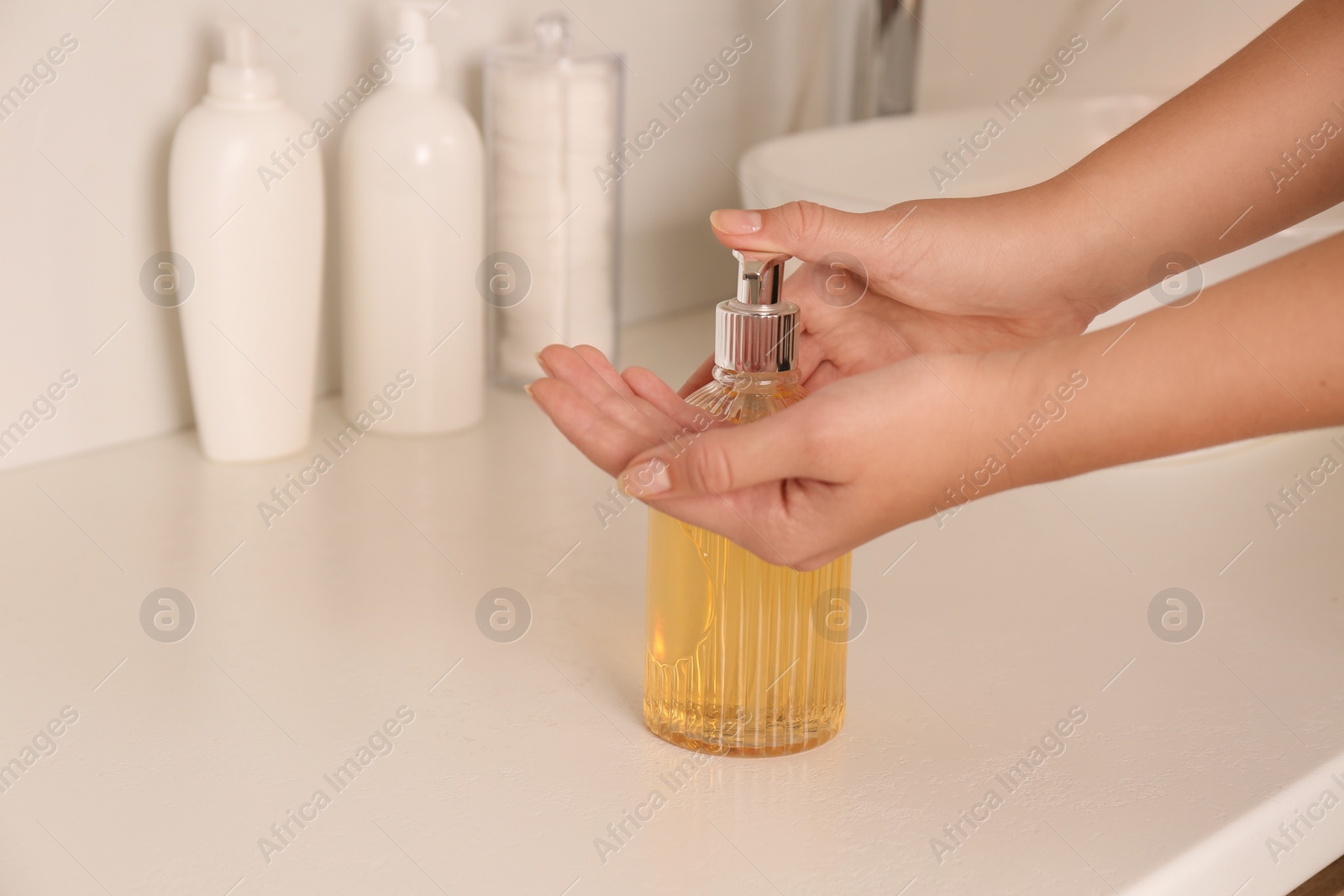 Photo of Woman using liquid soap in bathroom, closeup