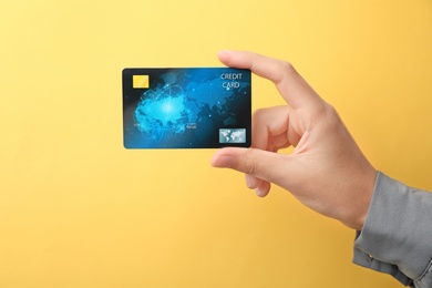 Photo of Woman holding credit card on color background