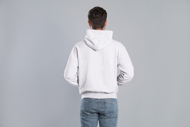 Photo of Young man in sweater on grey background. Mock up for design