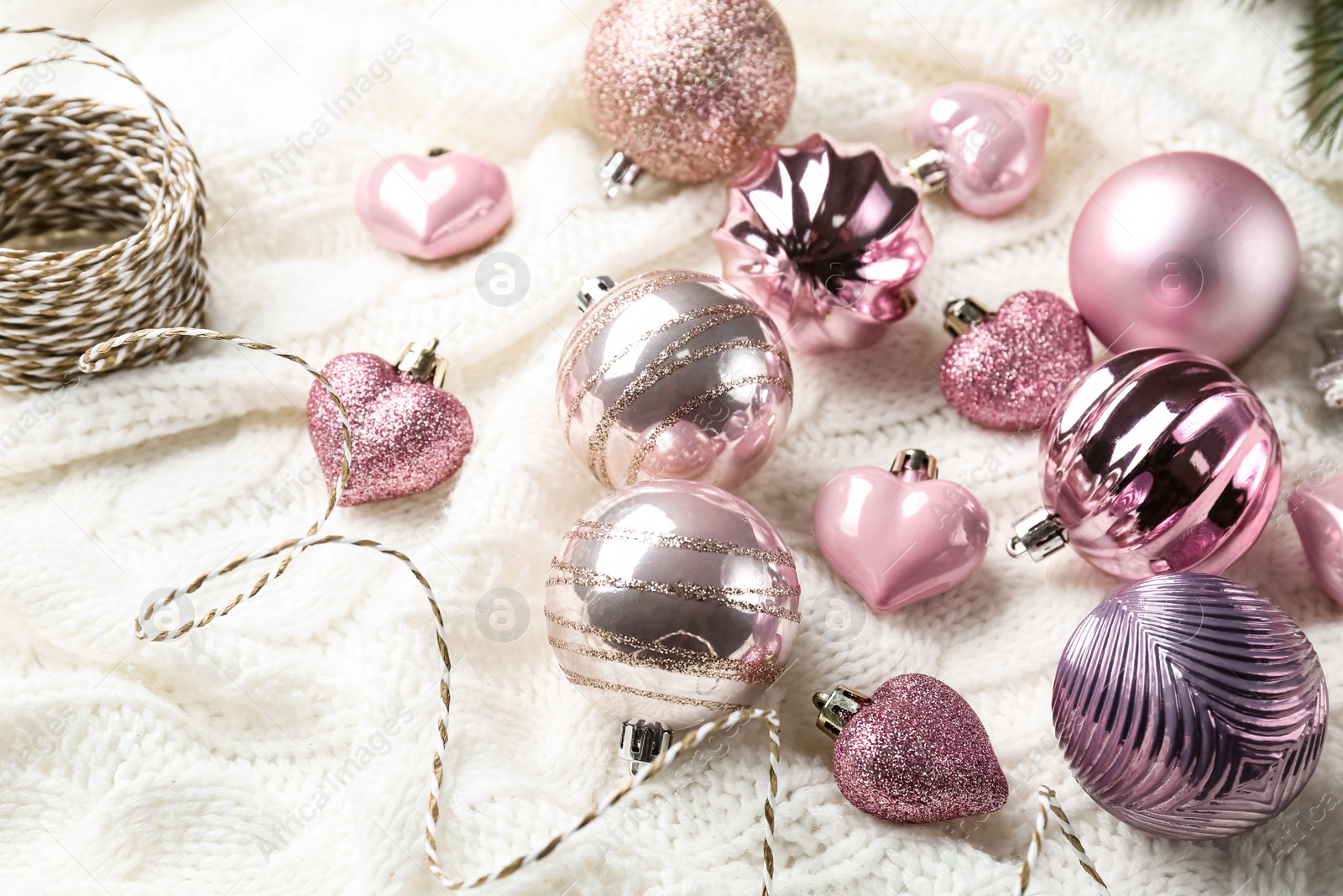 Photo of Beautiful pink Christmas baubles on white knitted plaid