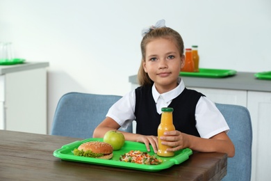 Photo of Happy girl with healthy food for lunch in school canteen